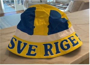 bright blue and yellow bucket hat with "SVE RIGE" visible lettering at its bottom