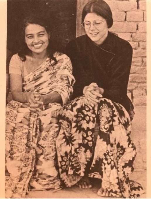 monochrome historical photo of two women sitting and smiling