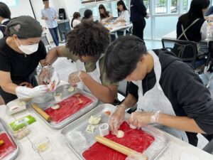 Two students learn to make a traditional Korean dish alongside a chef.