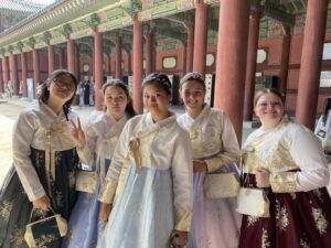 Five students pose for a photo while wearing traditional Korea clothing.