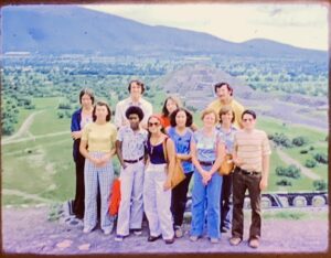A vintage photo of 11 young people standing as a group in front of Mexican landscape.