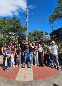 An Experiment in International Living group of students standing in front of a tall stone monument at the equator.