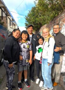 An Experiment in International Living student poses on a city street with her homestay family: three adults and two younger children.